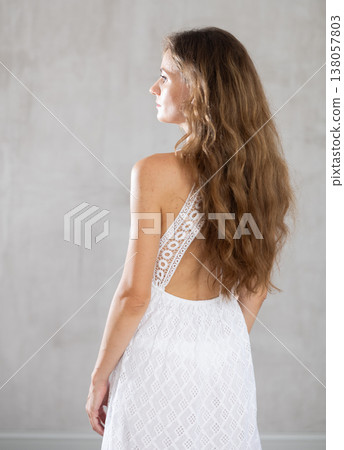 Young serious woman posing against wall background 138057803