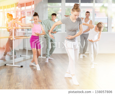 Girls and boys are learning various dance and ballet movements in studio Girls and boys are learning various dance and ballet movements in studio 138057806