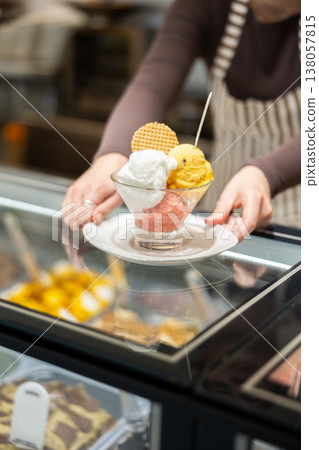 Unrecognizable girl serves ice cream and waffle desserts Unrecognizable girl serves ice cream and waffle desserts 138057815