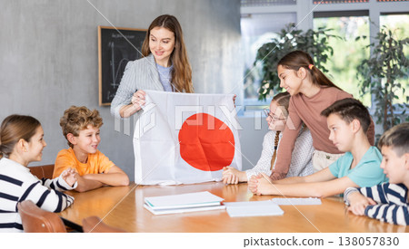 Female teacher shows scholchildren national flag of Japan 138057830