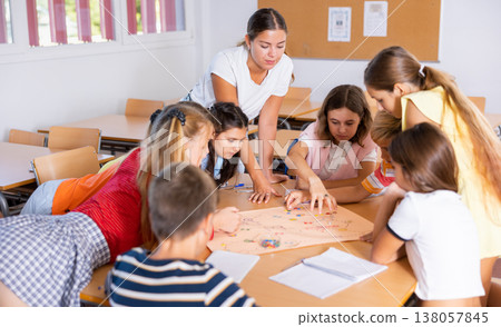 Teacher and pupils playing board game in school Teacher and pupils playing board game in school 138057845