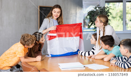 Teacher showing Holland flag to group of schoolchildren 138057849