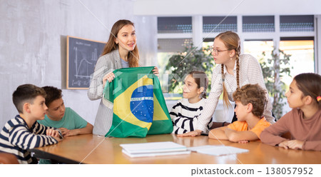 Teacher showing Brazil flag to group of schoolchildren 138057952