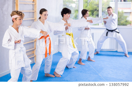 Children students repeat position and perform sequence of punches and painful techniques kata Children students repeat position and perform sequence of punches and painful techniques kata 138057992