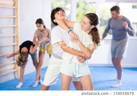 Boy and girl train to perform works out blow to jaw at opponent, while learning self-defense Boy and girl train to perform works out blow to jaw at opponent, while learning self-defense 138058079
