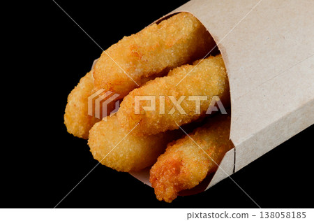 Crispy fried cheese stick in eco craft paper pocket on black background side view extreme close up delicious savory junk food take out Crispy fried cheese stick in eco craft paper pocket on black background side view extreme close up delicious savory junk food take out 138058185