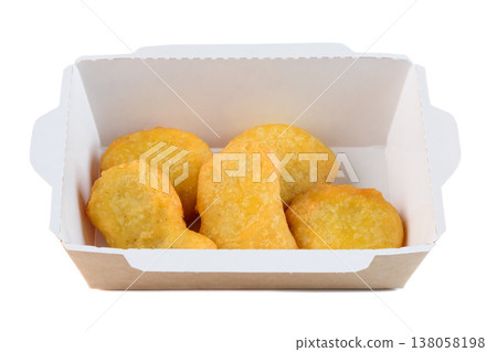 Crispy golden chicken nugget in craft paper takeout container on white background side view close up with copy space delicious savory meat snack Crispy golden chicken nugget in craft paper takeout container on white background side view close up with copy space delicious savory meat snack 138058198