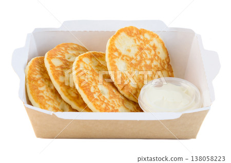Sweet thick pancake with sour cream in craft paper take out box on white background side view close up with copy space delicious savory breakfast 138058223