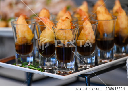 Catering shrimp tempura appetizer in glass shot with soy sauce on buffet tray for event or party decoration with no people and copy space delicious Catering shrimp tempura appetizer in glass shot with soy sauce on buffet tray for event or party decoration with no people and copy space delicious 138058224
