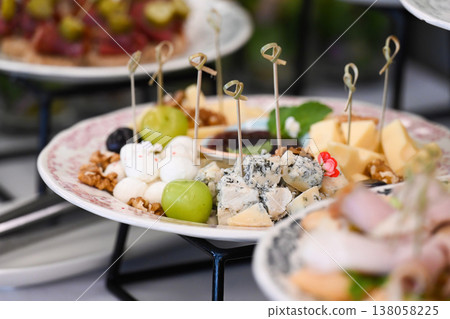 Assorted catering cheese platter with blue cheese mozzarella walnut and grape on buffet table for event or party decoration with delicious snacks Assorted catering cheese platter with blue cheese mozzarella walnut and grape on buffet table for event or party decoration with delicious snacks 138058225