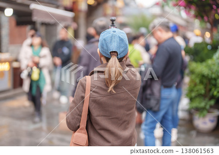 Happy woman traveler travel in Chengdu city. Tourist sightseeing and shopping in Kuan Zhai Alley or wide and narrow alleys, Famous Landmark for tourism attraction in Sichuan, China Happy woman traveler travel in Chengdu city. Tourist sightseeing and shopping in Kuan Zhai Alley or wide and narrow alleys, Famous Landmark for tourism attraction in Sichuan, China 138061563