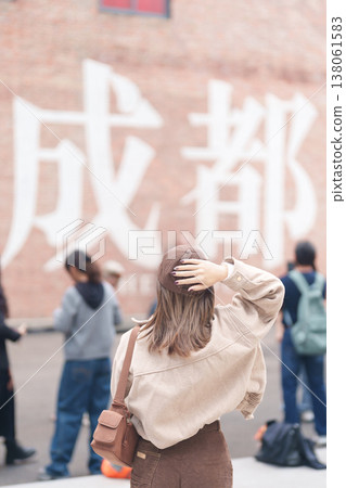 Happy woman traveler travel in Chengdu city. Tourist sightseeing and shopping in Eastern Suburb Memory or Dongjiao Ji Yi. Famous Landmark for tourism attraction in Sichuan, China Happy woman traveler travel in Chengdu city. Tourist sightseeing and shopping in Eastern Suburb Memory or Dongjiao Ji Yi. Famous Landmark for tourism attraction in Sichuan, China 138061583