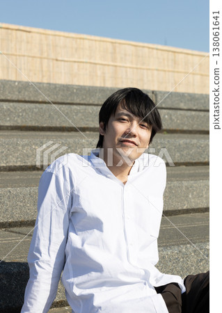 一名男子坐在石階上放鬆休息。 一名男子坐在石階上放鬆休息。 138061641