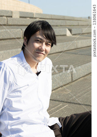 一名男子坐在石階上放鬆休息。 一名男子坐在石階上放鬆休息。 138061643