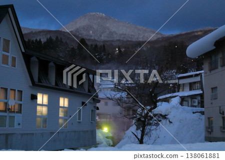 Evening view of Zao Onsen with lights shining in the windows of the buildings. 138061881
