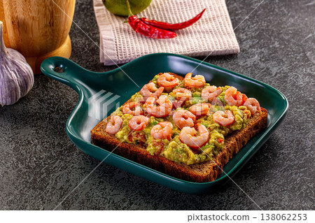 Gourmet toast with shrimp and guacamole avocado spread on rye bread with fresh ingredients. Gourmet toast with shrimp and guacamole avocado spread on rye bread with fresh ingredients. 138062253