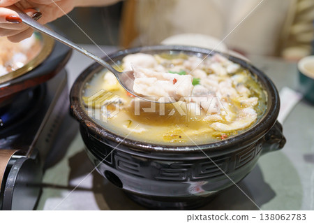 Woman tourist eating Sichuan Fish with Pickled Mustard Greens or Suan Cai Yu in restaurant. Popular foods for tourist eating in Chengdu, Chongqing and China. Chinese Asia and Sichuan foods concept 138062783