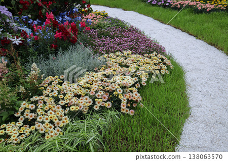 March 21 2026 Colorful Garden Flower Bed With Daisies Lining A Curved Gravel March 21 2026 Colorful Garden Flower Bed With Daisies Lining A Curved Gravel 138063570