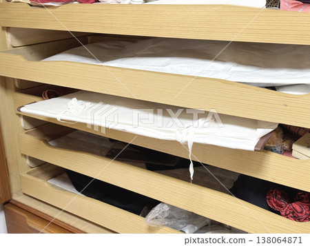 A paulownia wood chest of drawers with the wrapping paper sticking out. 138064871