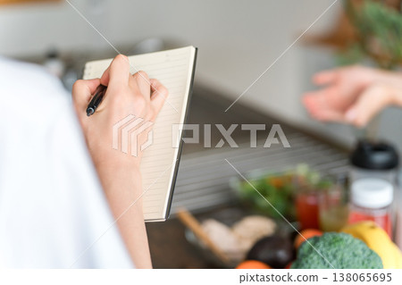 A woman's hands taking notes in a cooking class/cooking school. 138065695