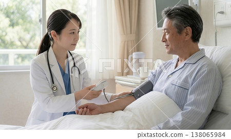 A female doctor talking to a hospitalized patient in their room. 138065984