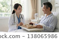 A female doctor talking to a hospitalized patient in their room. 138065986