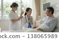 A female doctor talking to a hospitalized patient in their room. 138065989