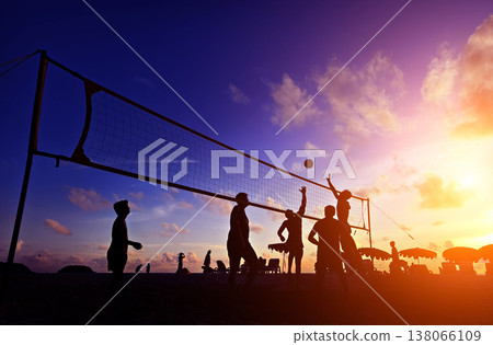 Young people playing beach volleyball by the ocean at sunset Young people playing beach volleyball by the ocean at sunset 138066109