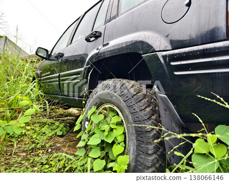 Abandoned jeep lost amidst lush foliage and decay Abandoned jeep lost amidst lush foliage and decay 138066146