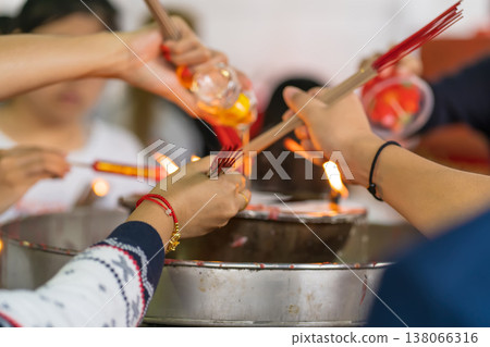 Hands lighting incense together Hands lighting incense together 138066316