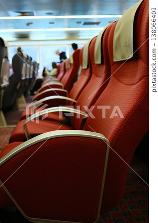 Rows of red and gray reclining passenger seats inside high speed ferry cabin on Hong Kong Macau route 138066401