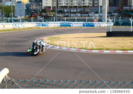 Motorcycle racer on colorful racing bike speeding on Macau Grand Prix street circuit track sunny day Motorcycle racer on colorful racing bike speeding on Macau Grand Prix street circuit track sunny day 138066430