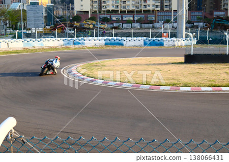 Motorcycle racer on colorful racing bike speeding on Macau Grand Prix street circuit track sunny day 138066431