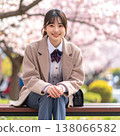 A spring portrait of a girl in a school uniform-like outfit, smiling while sitting on a bench in a park full of cherry blossoms in full bloom. 138066582