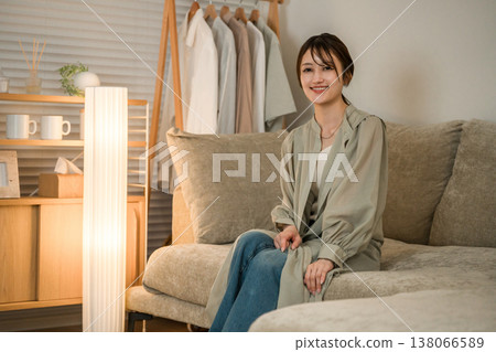 一位年輕的亞洲女性晚上在客廳的沙發上放鬆休息。 138066589