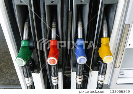 Fuel pump nozzles hanging at a modern gas station during a period of high oil prices. A conceptual photography showcasing the global energy crisis, increasing gasoline costs 138066869