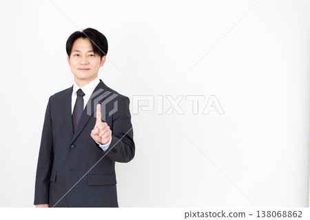 A middle-aged businessman holding up his index finger. 138068862