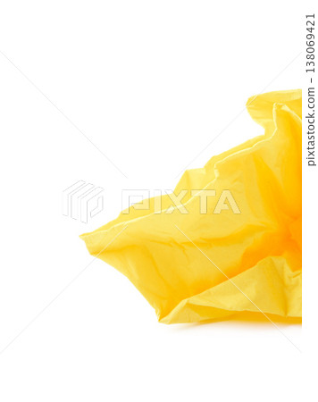 Wrinkled yellow paper placed on a white surface with soft light shining from above 138069421