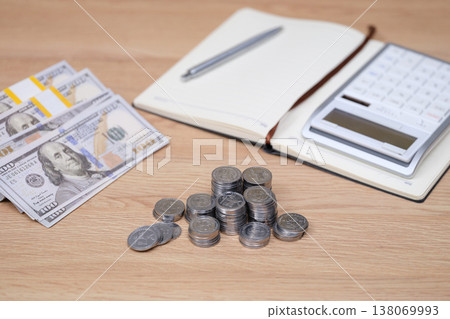 Managing finances with cash, coins, and a calculator, while drafting notes for budgeting at home 138069993