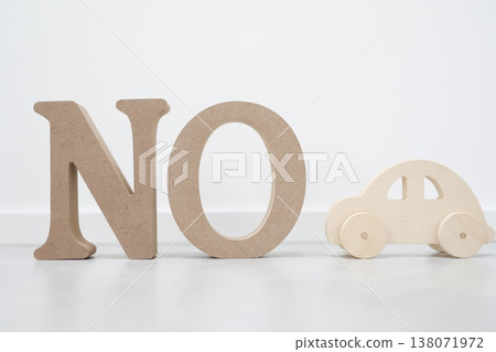 A "NO" sign discouraging car use and a wooden toy. A "NO" sign discouraging car use and a wooden toy. 138071972