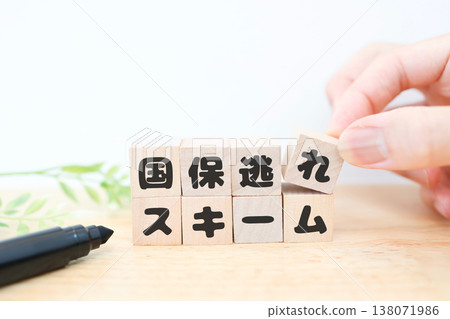 This shows a scheme to evade national health insurance payments. The image features wooden blocks against a white background. This shows a scheme to evade national health insurance payments. The image features wooden blocks against a white background. 138071986