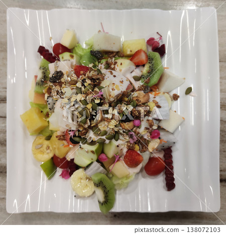 Fresh Mixed Fruit Salad with Kiwi, Dragon Fruit, Apple, Cherry Tomatoes, and Granola Topping Served on a White Plate Fresh Mixed Fruit Salad with Kiwi, Dragon Fruit, Apple, Cherry Tomatoes, and Granola Topping Served on a White Plate 138072103