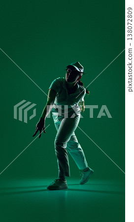 Female cricket player mid action throw with strong shadows in green lighting. Female cricket player mid action throw with strong shadows in green lighting. 138072809