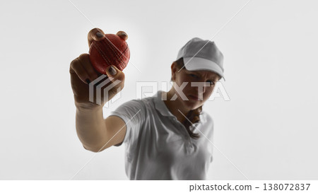 Female cricket player holding cricket ball toward camera isolated on white background. Female cricket player holding cricket ball toward camera isolated on white background. 138072837