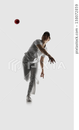 Female cricket bowler releasing ball in forward motion isolated on white. Female cricket bowler releasing ball in forward motion isolated on white. 138072859