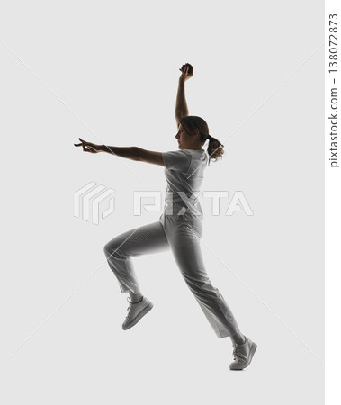 Female cricket bowler performing dynamic delivery action isolated on white. Female cricket bowler performing dynamic delivery action isolated on white. 138072873