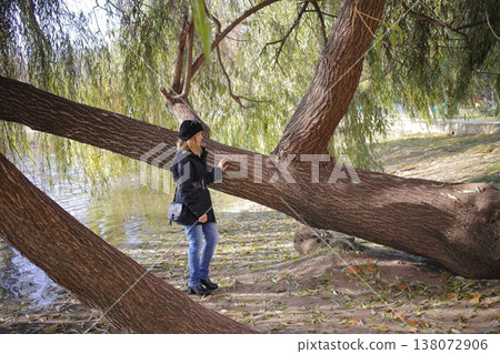 A young woman walks through the autumn park. A young woman walks through the autumn park. 138072906
