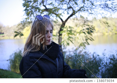 A young woman walks through the autumn park. A young woman walks through the autumn park. 138073034