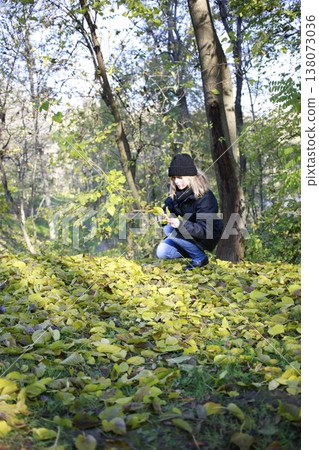 A young woman walks through the autumn park. 138073036