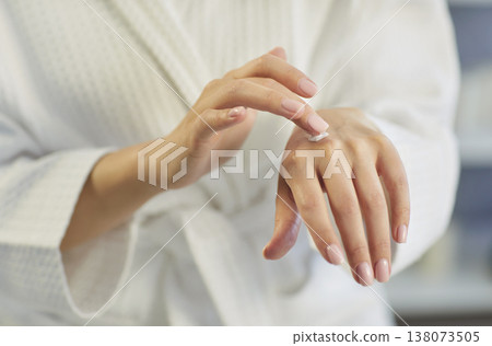 Close up of woman applying moisturizing natural cream on her hand for skin care and protection. Close up of woman applying moisturizing natural cream on her hand for skin care and protection. 138073505